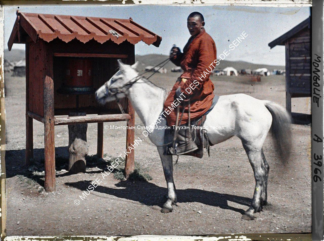 A monk on horseback in front of a prayer wheel behind Gandan (?). Musée Albert-Kahn. A 3966. Photo by Stéphane Passet, 23 July 1913